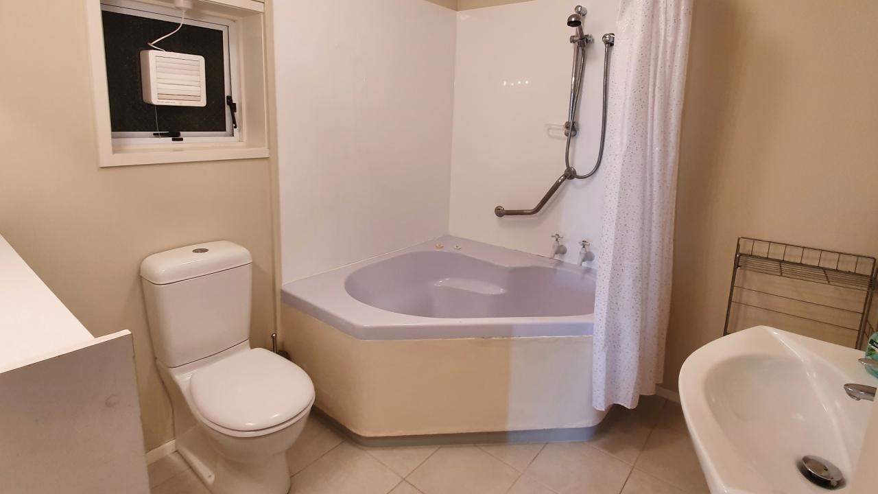Bathroom with shower over bath, toilet & vanity
