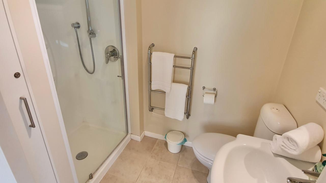 Main bedroom ensuite bathroom with shower, hair dryer, heated towel rails & wall heater.
