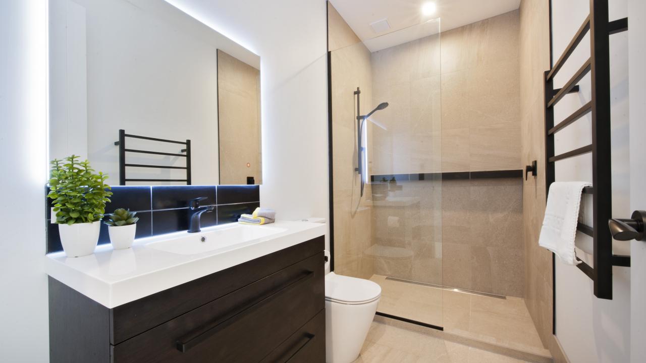 Main bathroom with walk in tile shower, toilet & vanity
