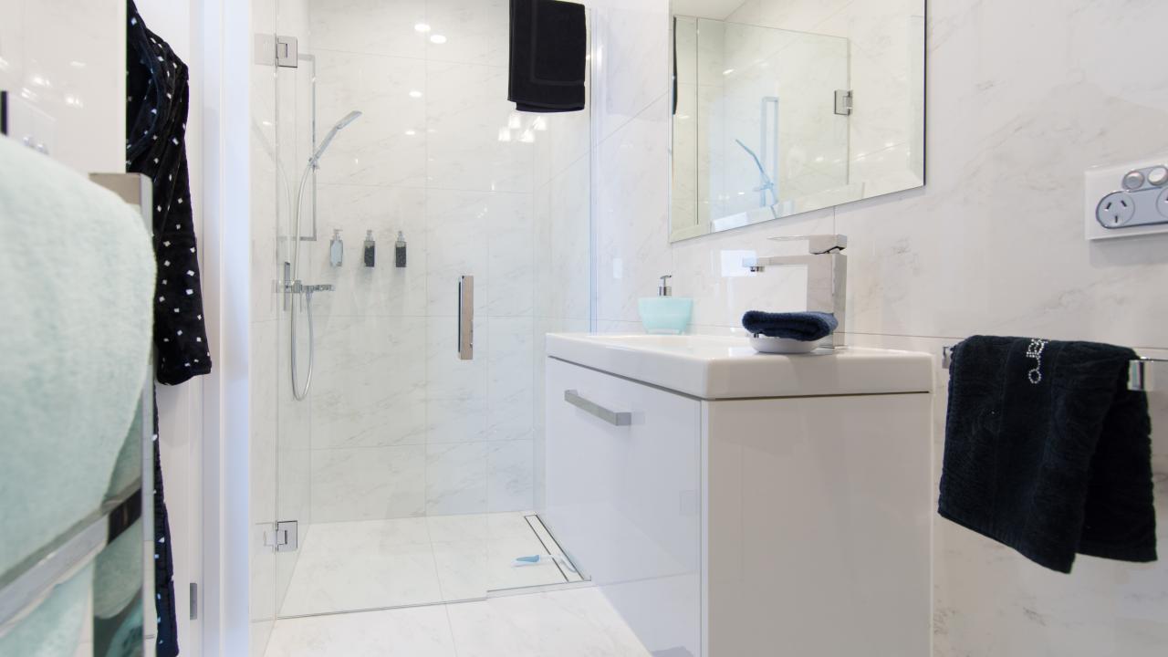 Gorgeous tile bathroom with shower, vanity & toilet.
