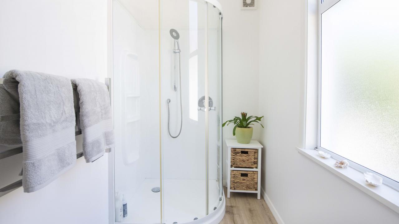 Bathroom with shower and vanity. Separate toilet.