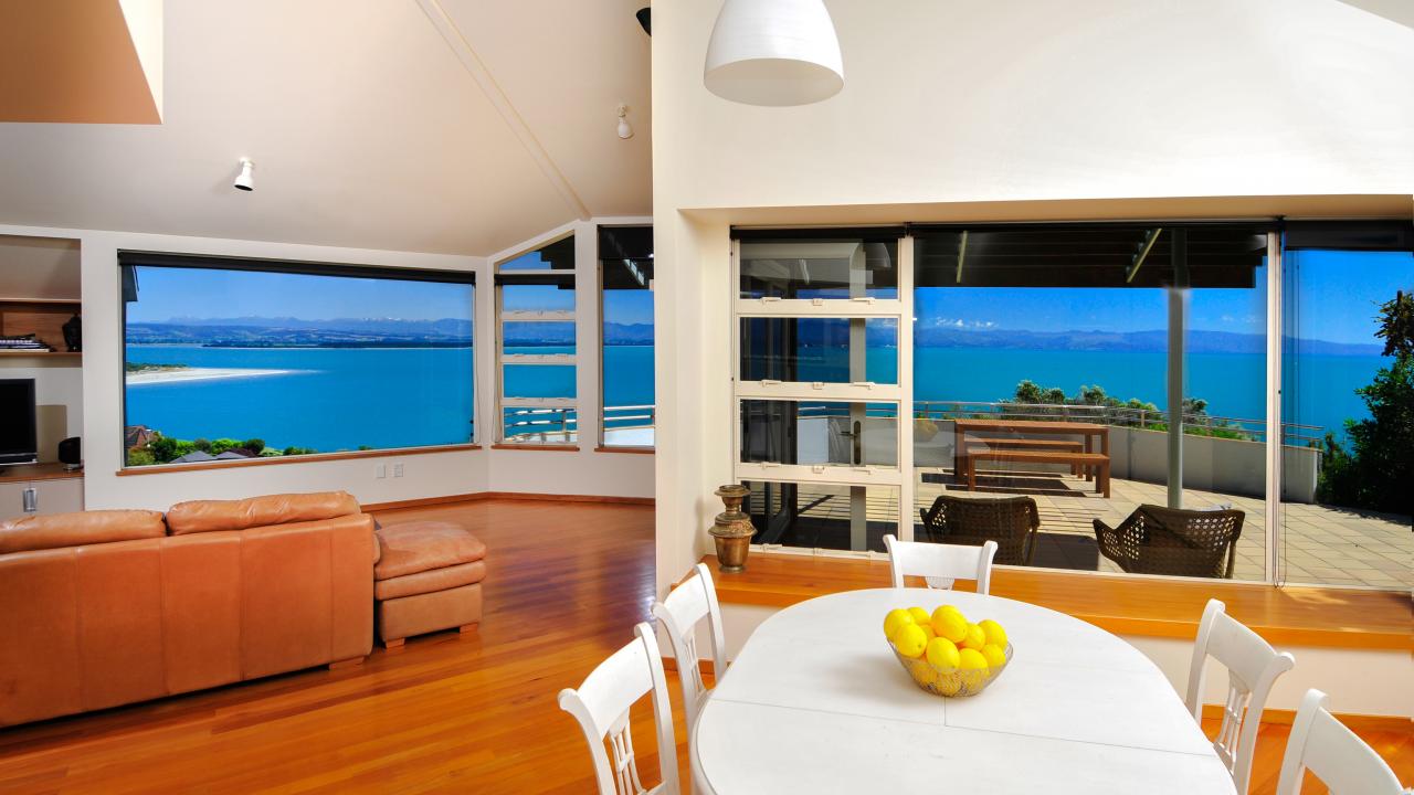Open-plan living-dining-kitchen opening to large balcony area