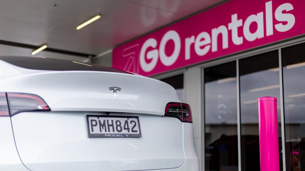 Back of a Tesla Model Y parked outside a GO Rentals branch.