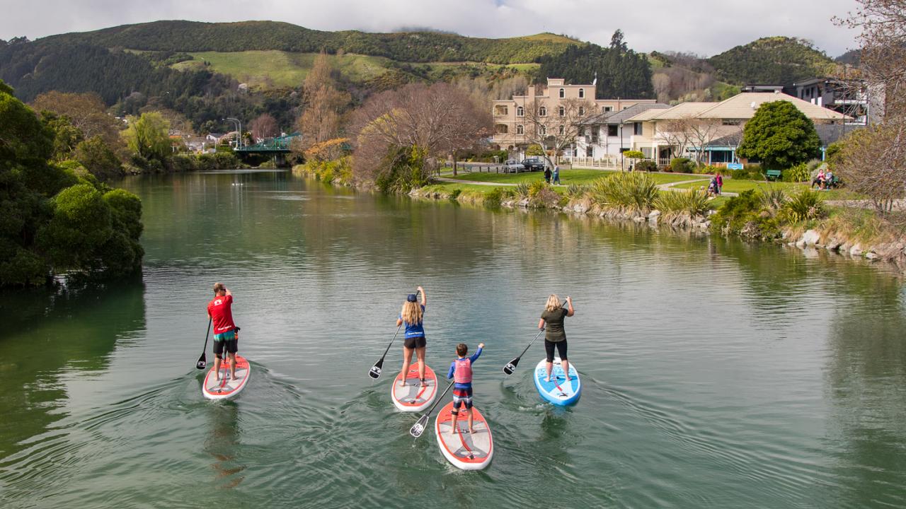 Paddling the Maitai River on standup paddleboards.