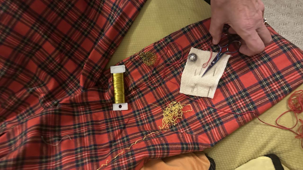 A student works with their tutor to learn how to embellish an old shirt at their Embellish Me Workshop.