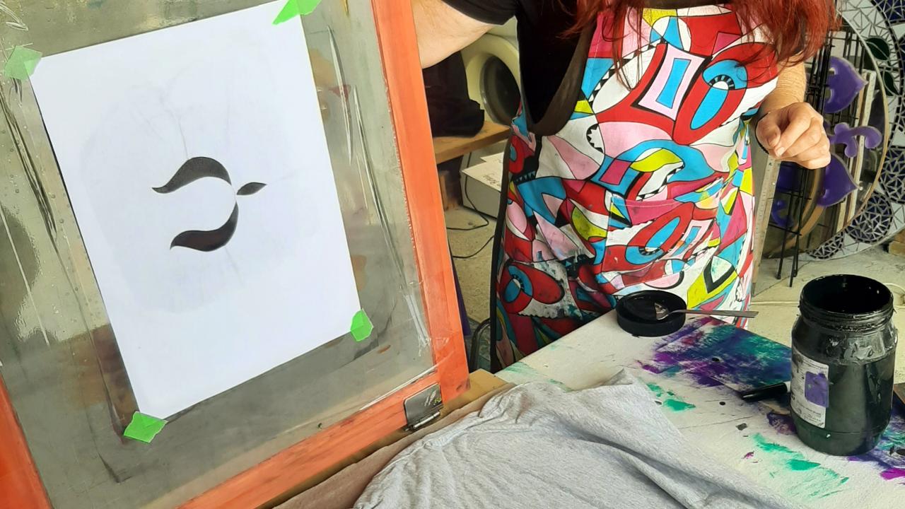 A student prints their design onto a t-shirt at their Create Fabulous Screen Prints on Fabric or Paper Workshop.