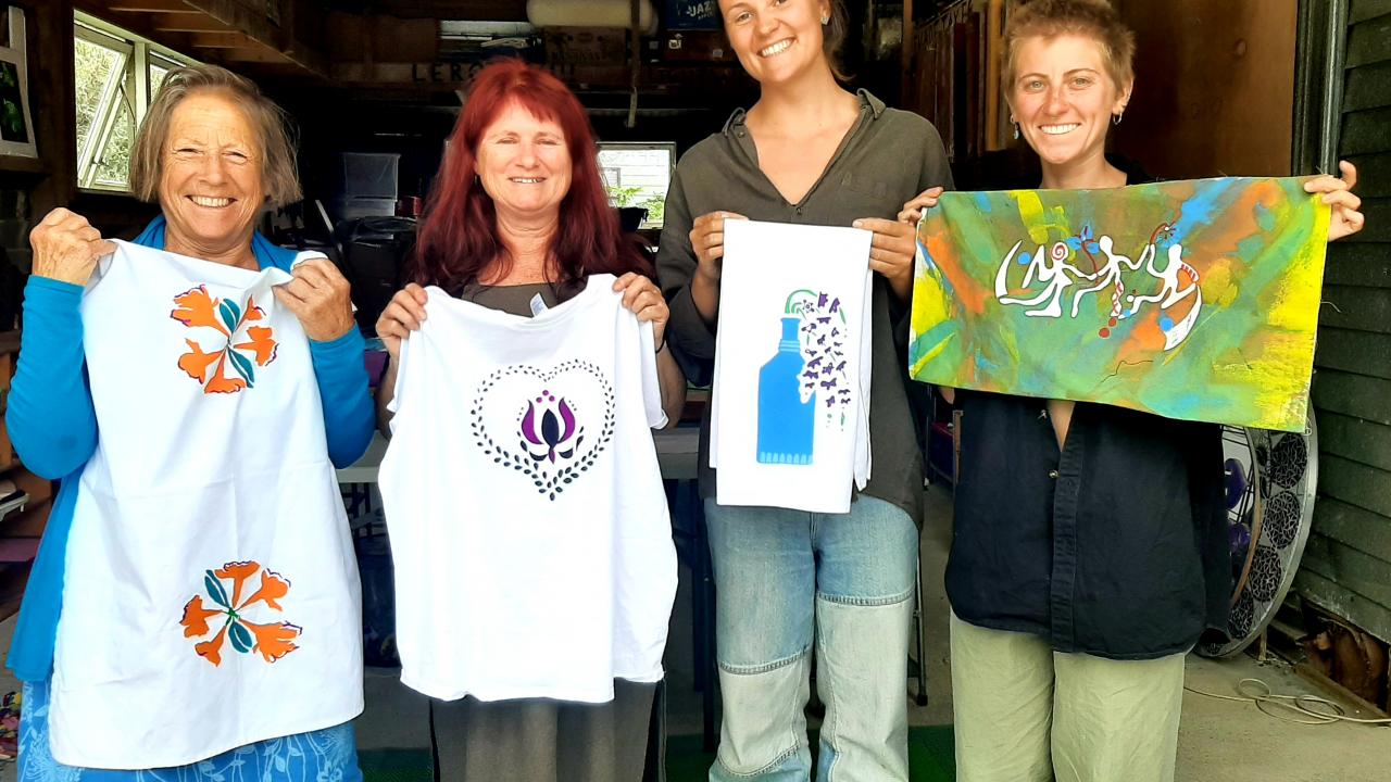Students proudly hold up their screen printed designs at their Create Fabulous Screen Prints on Fabric or Paper Workshop.