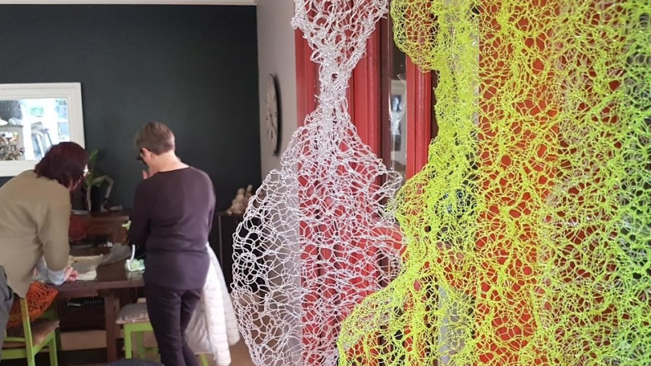 A student works with their tutor on a piece of art at their Transformational Textiles Workshop.
