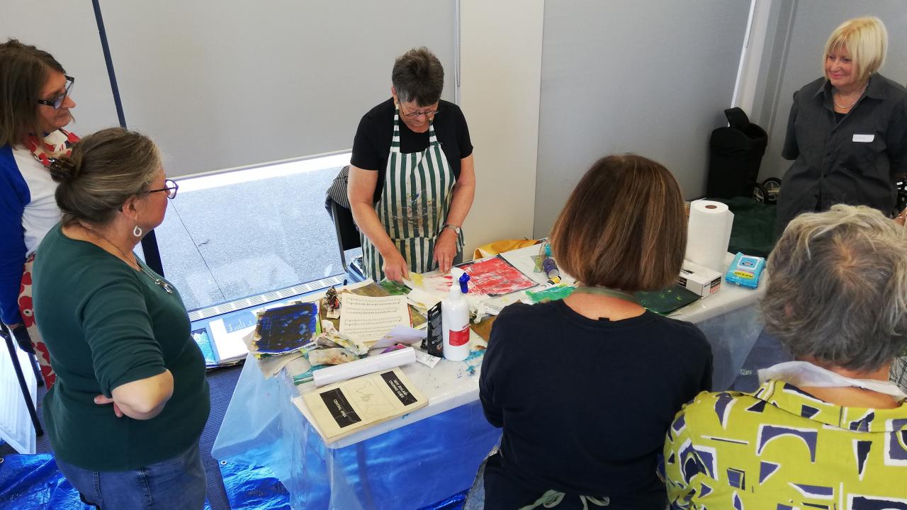 Students work with their tutor to create works of art during their Create a Unique Collaged Floral Fantasy Workshop.