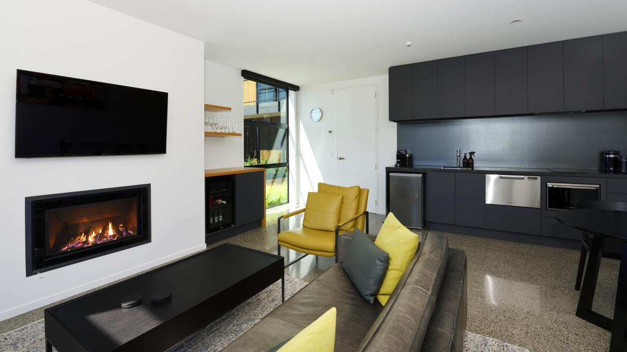 Living area with gas fire for cosy nights, and kitchen in the background