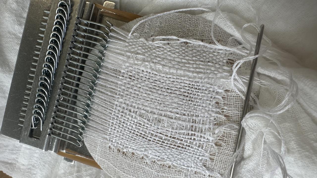 An example of speedweve mending on white linen fabric.