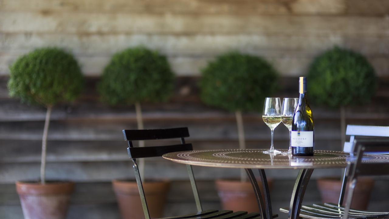 A glass of Moutere Chardonnay in the cellar door garden at Neudorf.