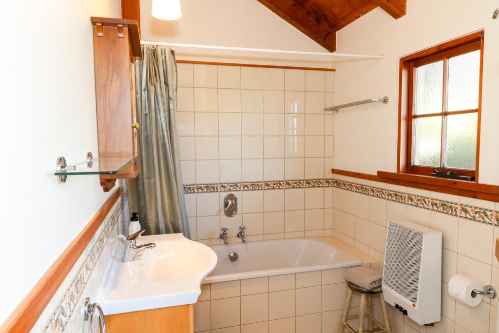 The beautifully tiled bathroom contains a shower and a bathtub for the ultimate luxury experience. Simone Jackson