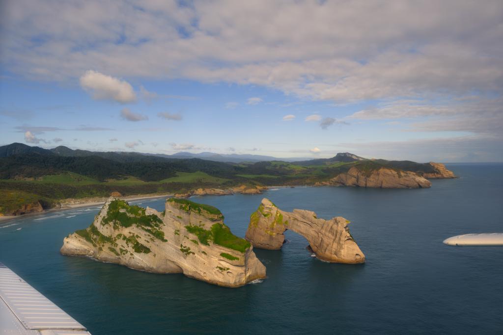 The famous Wharariki Beach arches from Golden Bay Air's West Coast and Farewell Spit scenic flight